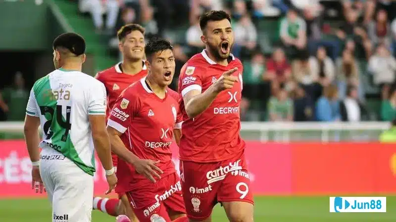 Cầu thủ Huracan đi bóng qua cầu thủ Banfield trong trận đấu sôi động