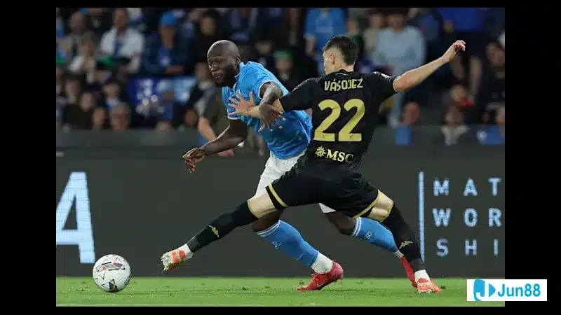 Cầu thủ Napoli điều chỉnh bóng trước sự áp sát của cầu thủ Genoa trên sân Cầu thủ Napoli điều chỉnh bóng trước sự áp sát của cầu thủ Genoa trên sân