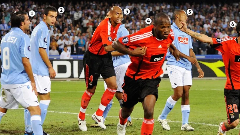 Cầu thủ Benfica với sự quyết tâm chạy bóng qua cầu thủ Napoli trên sân cỏ
